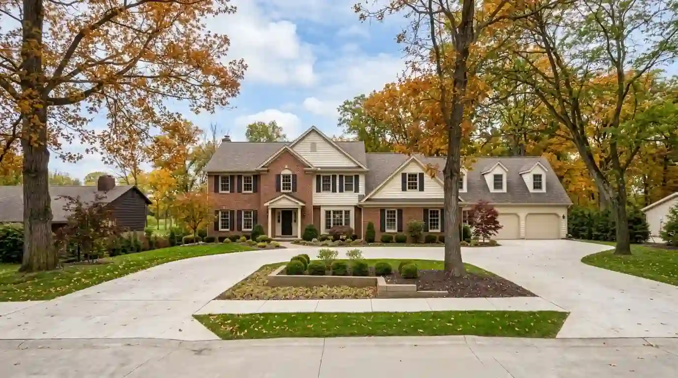 Two-story 1980s colonial with an attached garage and bonus room in Pine Valley, Fort Wayne, early fall, maple trees turning orange along a curving street.